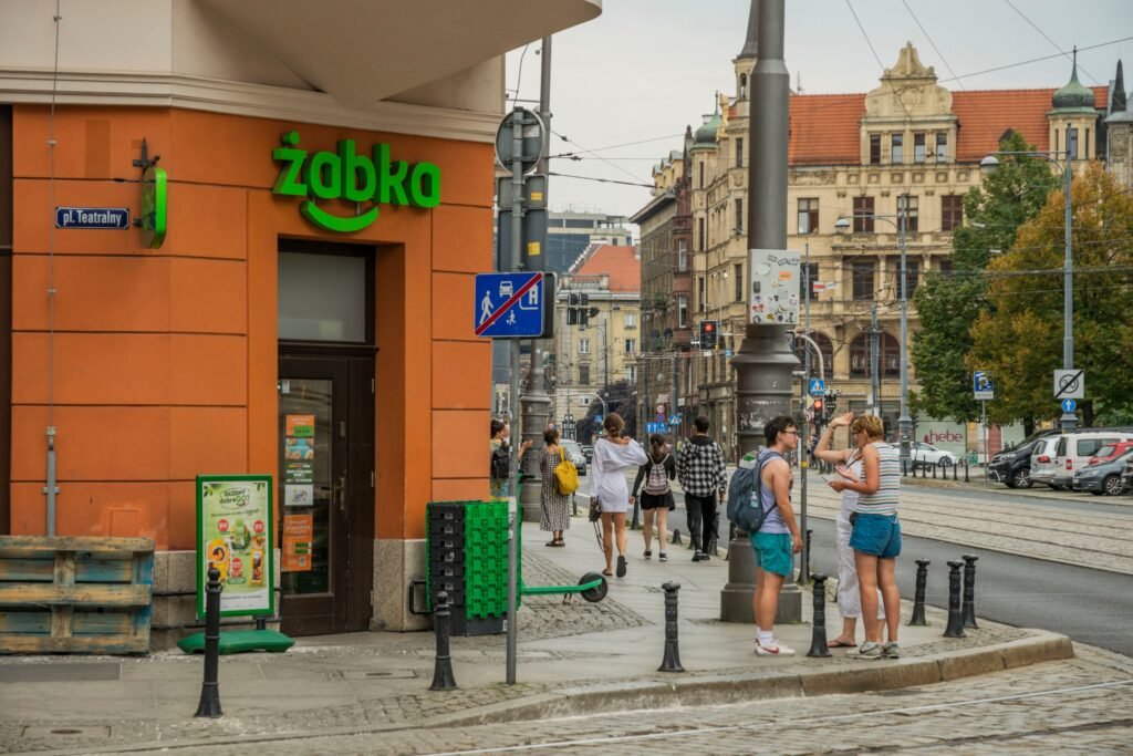 Urban street view in Wrocław, Poland, featuring people, cafes, and bustling city life.