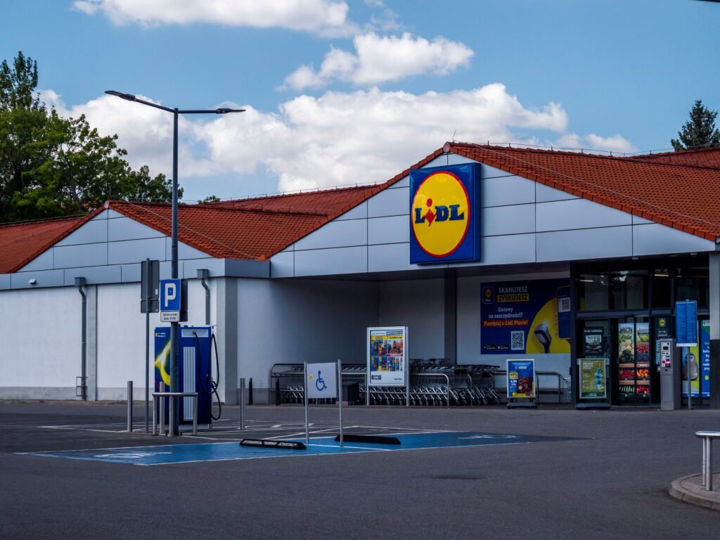 Lidl supermarket exterior featuring parking area and shopping carts on a sunny day.